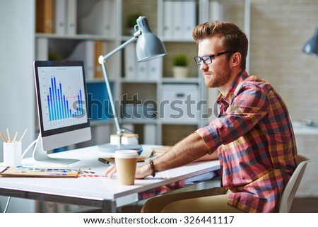 Young man looking at financial chart reflecting changes in market development