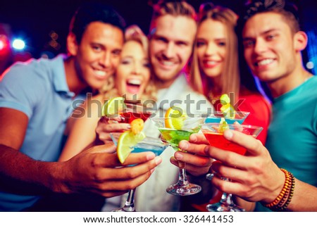 Group of young friends toasting with cocktails