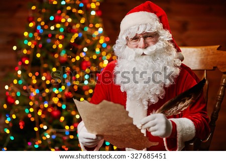 Happy Santa Claus with feather and Christmas letter