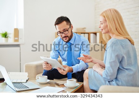 Small group of co-workers discussing project in office