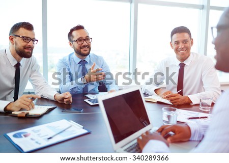 Happy businessmen looking at partner during conversation