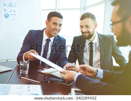 Young businessman offering his partner to sign contract after negotiation