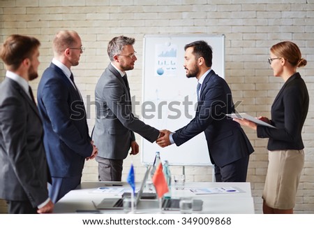 Business partners handshaking a deal at office