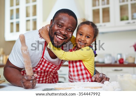 Joyful father and daughter cooking homemade pastry