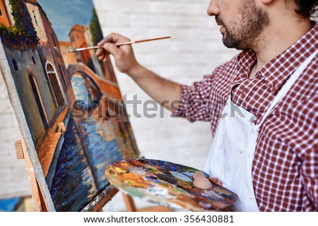 Modern artist painting landscape with oilpaints