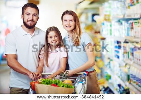Portrait of happy family standing in supermarket