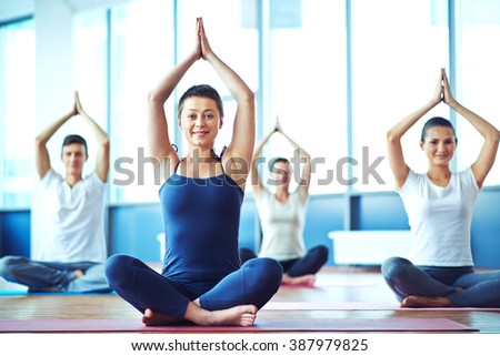 Young woman practicing yoga in yoga class in fitness center