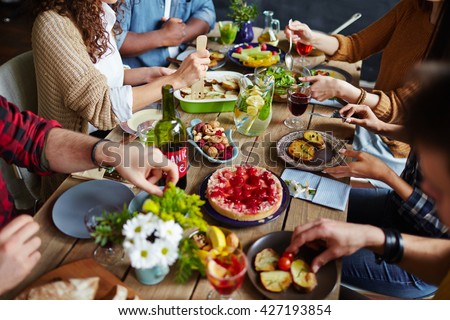 Group of people sitting at festive table and eating