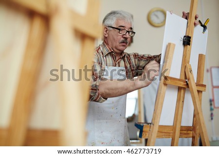 Male artist painting his picture at art studio