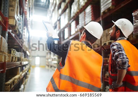 Revision managers discussing amount of loaded goods in racks