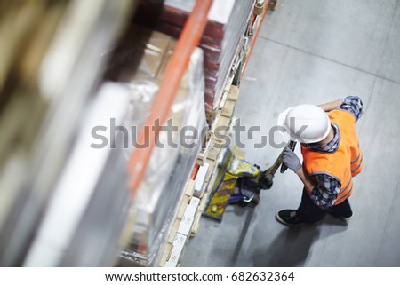 Above view of warehouse loader picking up heavy pellets  using forklift cart
