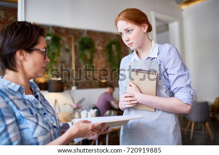 Displeased client of cafe complaining waitress about menu or bad service