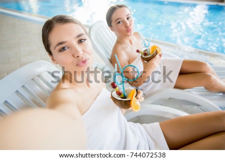 Girl with pina-colada giving you air kiss during relax at day spa salon