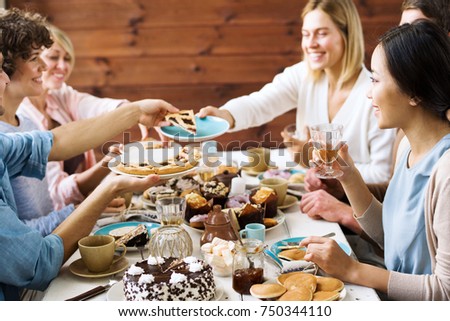 One of guests asking for slice of sweet pie during home celebration of holiday by festive table