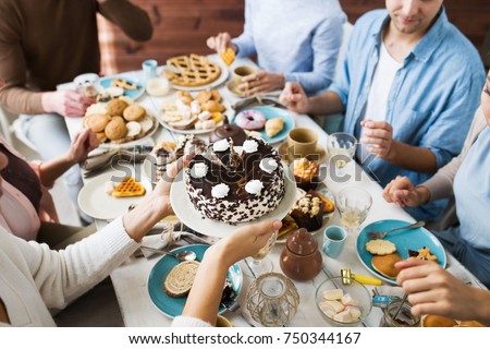 Young female bringing birthday cake with cream dollops on plate for her guests