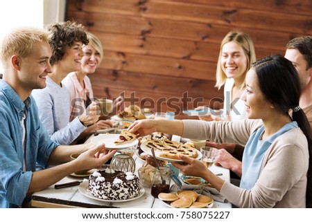 Young woman giving last piece of pie to smiling guy by festive table during xmas dinner
