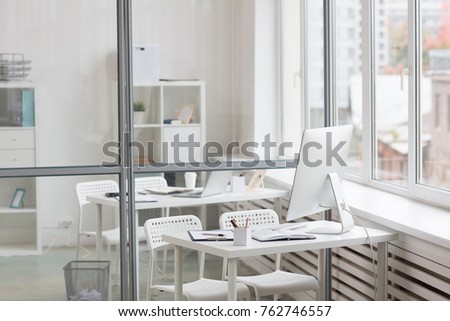 Empty office with desk, two chairs, computer and business supplies by the window