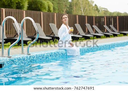 Young woman with juice enjoying her solitude at spa resort