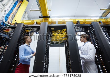 Staff of modern mining farm checking or testing new bitcoin storage system