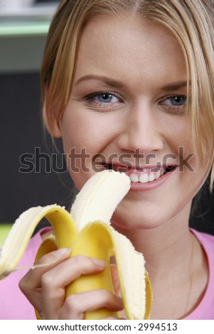 Portrait of young pretty woman eating the banana