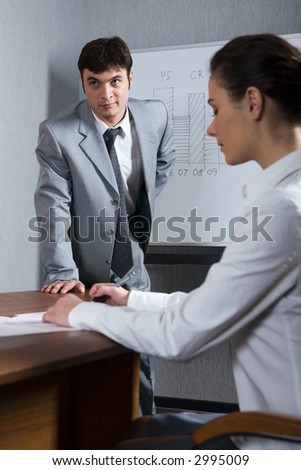 Businessman in the gray suit near the blackboard and writing woman