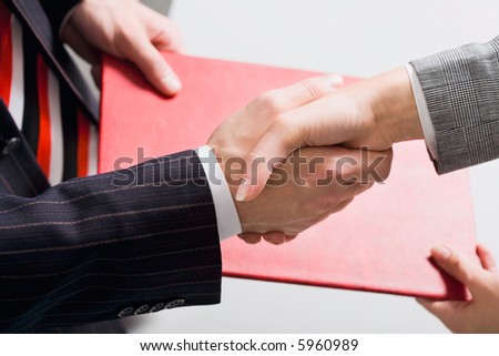 Moment of making an successful agreement: handshake and exchange of documents