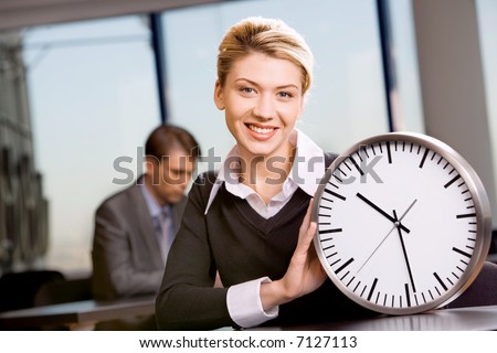 Portrait of responsible woman with watch in the office