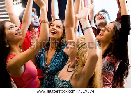 Portrait of laughing people raising their hands