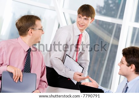 Portrait of three successful men chatting at business meeting