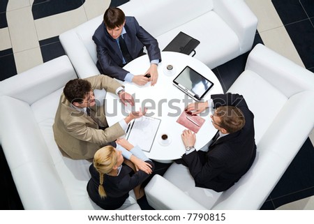 Portrait of businesspeople sitting around at the table and discussing an important questions