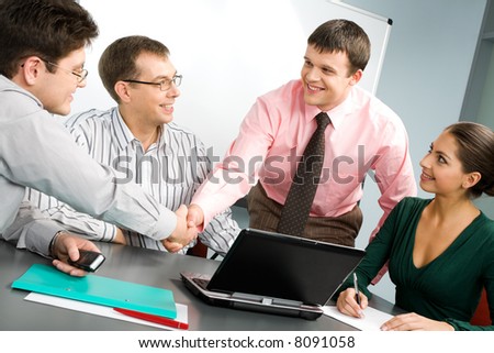 Portrait of confident people shaking hands at business meeting