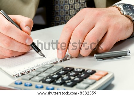 Image of writing instrument in male hands on a workplace