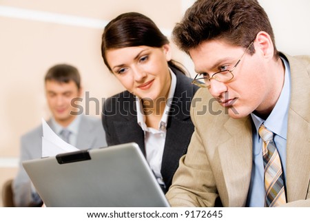 Successful business man and woman looking at the laptop in a working environment