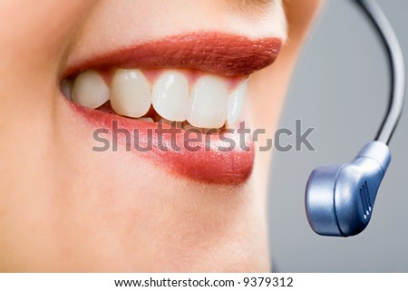 Close-up of smiling woman\'s mouth and teeth with microphone