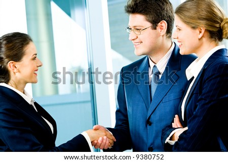 Business man and woman shaking hands making an agreement at meeting