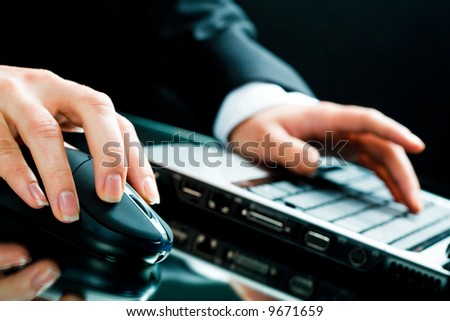 Image of human hands working on the laptop and computer mouse