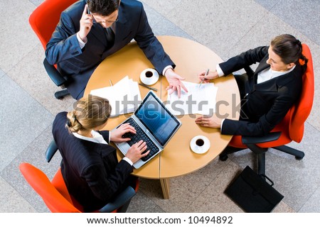 Portrait of three business person sitting at the round table