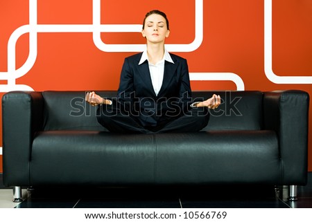 Portrait of business woman meditating on the sofa in the room