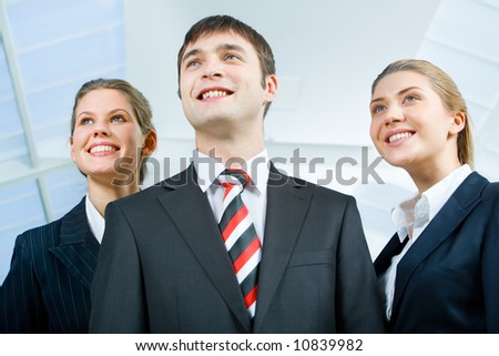 Image of three business people in suits and smiling