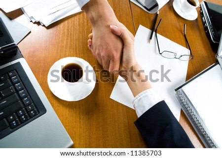 Handshake of business people over the workplace