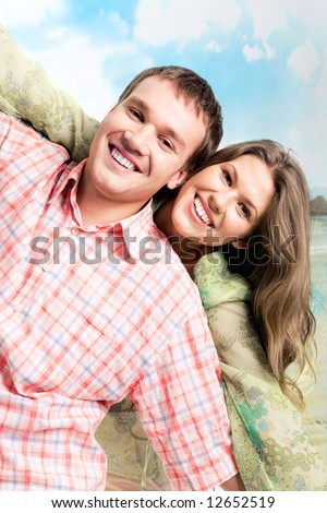 Photo of carefree couple holding each other’s hands and looking at camera with smiles