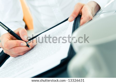 Close-up of woman’s hand holding pen over document during work