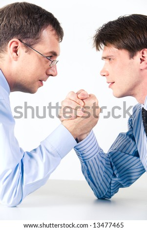 Conceptual photo of business competition: two businessmen wrestling with aggressive expression on their faces