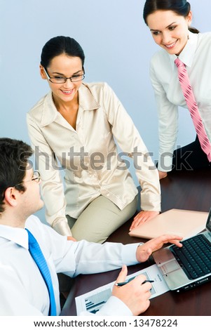 Vertical image of three business partners discussing working questions