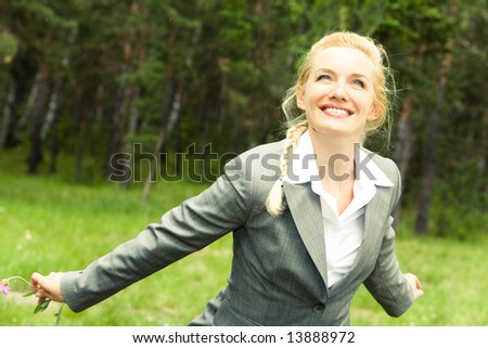 Portrait of happy businesswoman in suit in a natural environment