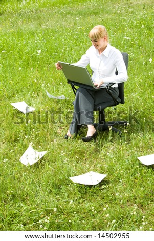 Photo of happy business lady working with laptop outside looking at its monitor