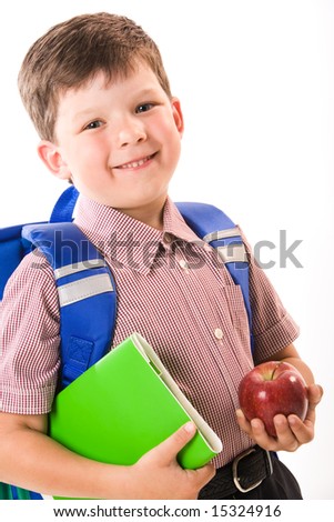 Portrait of smiling boy with apple and book ready to go to school
