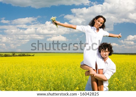 stock photo : Portrait of young man holding his happy girlfriend on hands