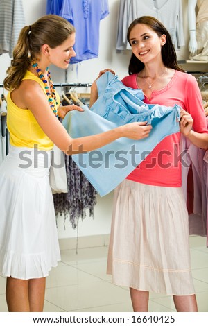 Portrait of two female friends discussing a blue t-shirt