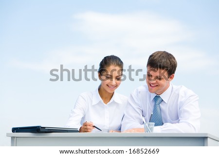 Portrait of man and woman sitting at the desk and interacting with each other
